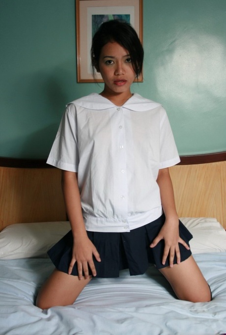 Hot Asian teen schoolgirl sheds her uniform to rub her bald pussy on the bed 51641659