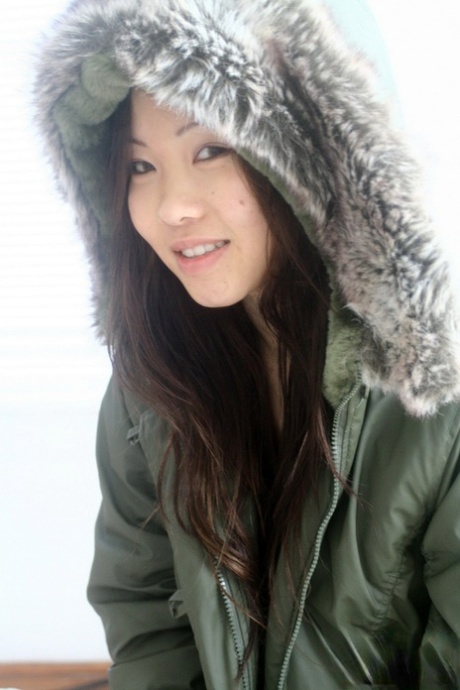 Asian amateur Grace removes a winter coat to model a thong during SFW action 57405942