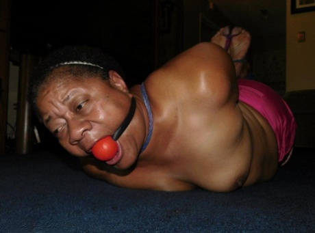 Ebony female drools while ball gagged and hogtied upon a bed 24974305