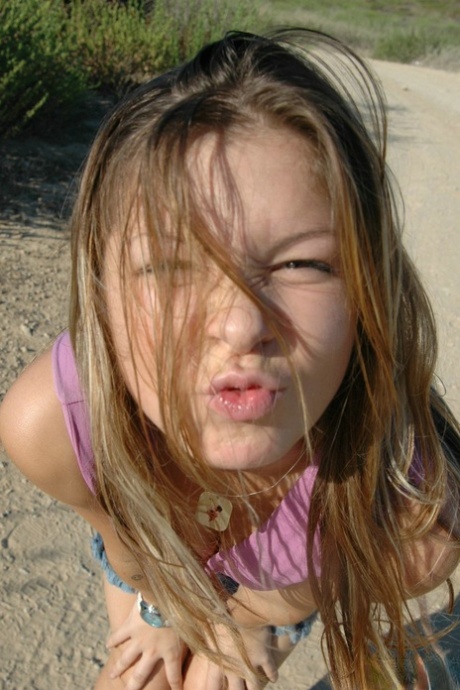 Young girl frolics on a dirt road well wearing a denim miniskirt and a thong 65481150
