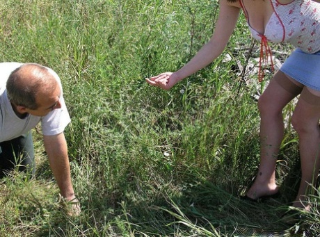 Caucasian woman straddles her submissive man's face outside in long grass 83963361