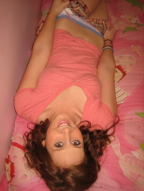 Young girl with wavy red hair gets completely naked atop her bed 28565288