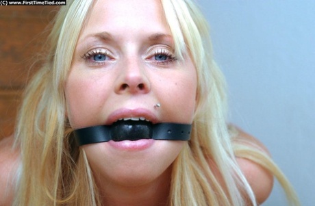Beautiful blonde in blue jeans handcuffed and ball gagged ready for BDSM play 49595770