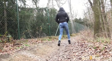 White girl Lilly pulls down ripped jeans to pee on leaves next to a path 31781913