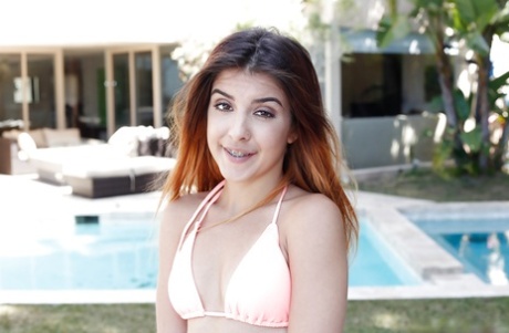 Young redhead Sally Squirt freeing tiny tits from bikini by swimming pool 64721140